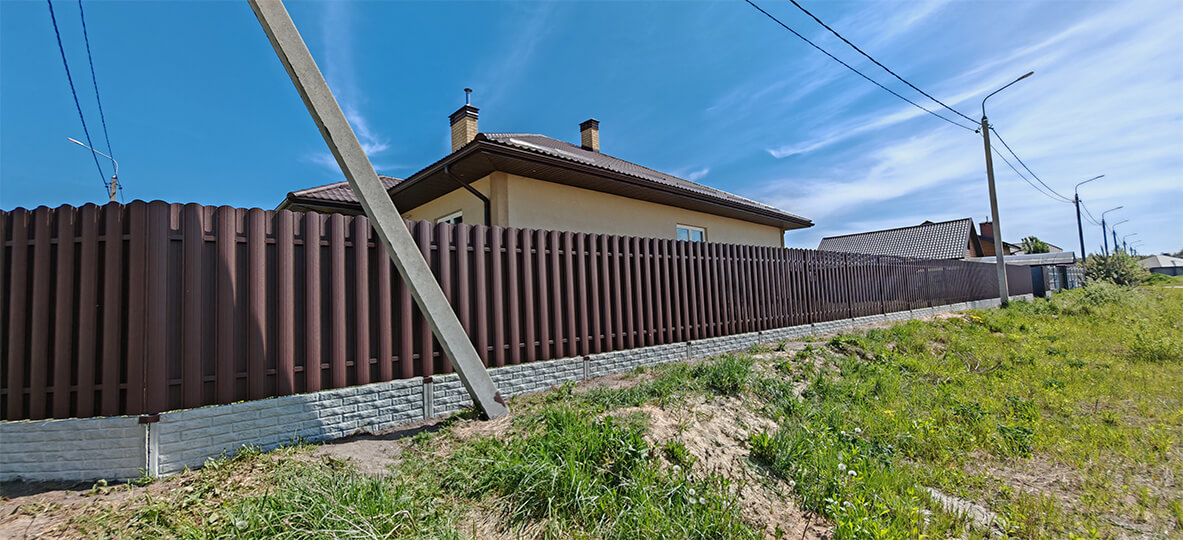 Забор из металлического штакетника коричневый на сборном фундамента