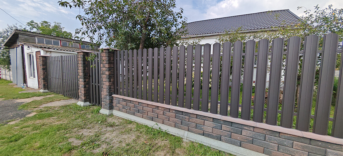 Забор из металлического штакетника на кирпиче