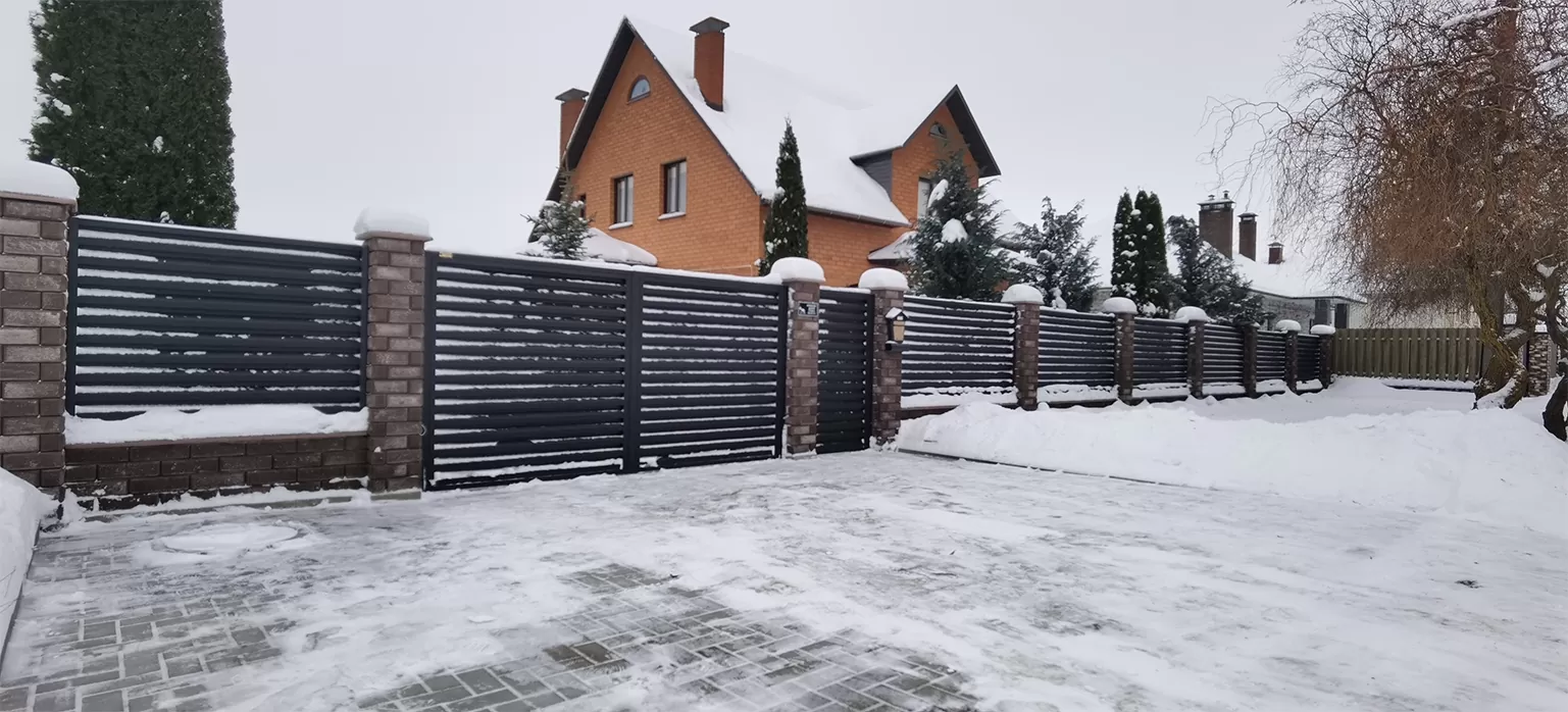 Забор жалюзи со столбами из коричневого кирпича